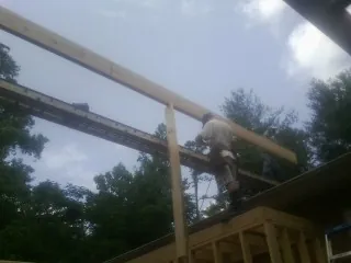 Carpenter setting a ridge beam over a new addition frame — Ice Dam Removal by Roofing Brothers in Pennville