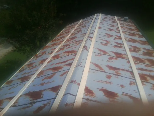 Rusted metal roof panels with new wood purlins before replacement — Storm Damage Roof Repair in Pennville by Roofing Brothers
