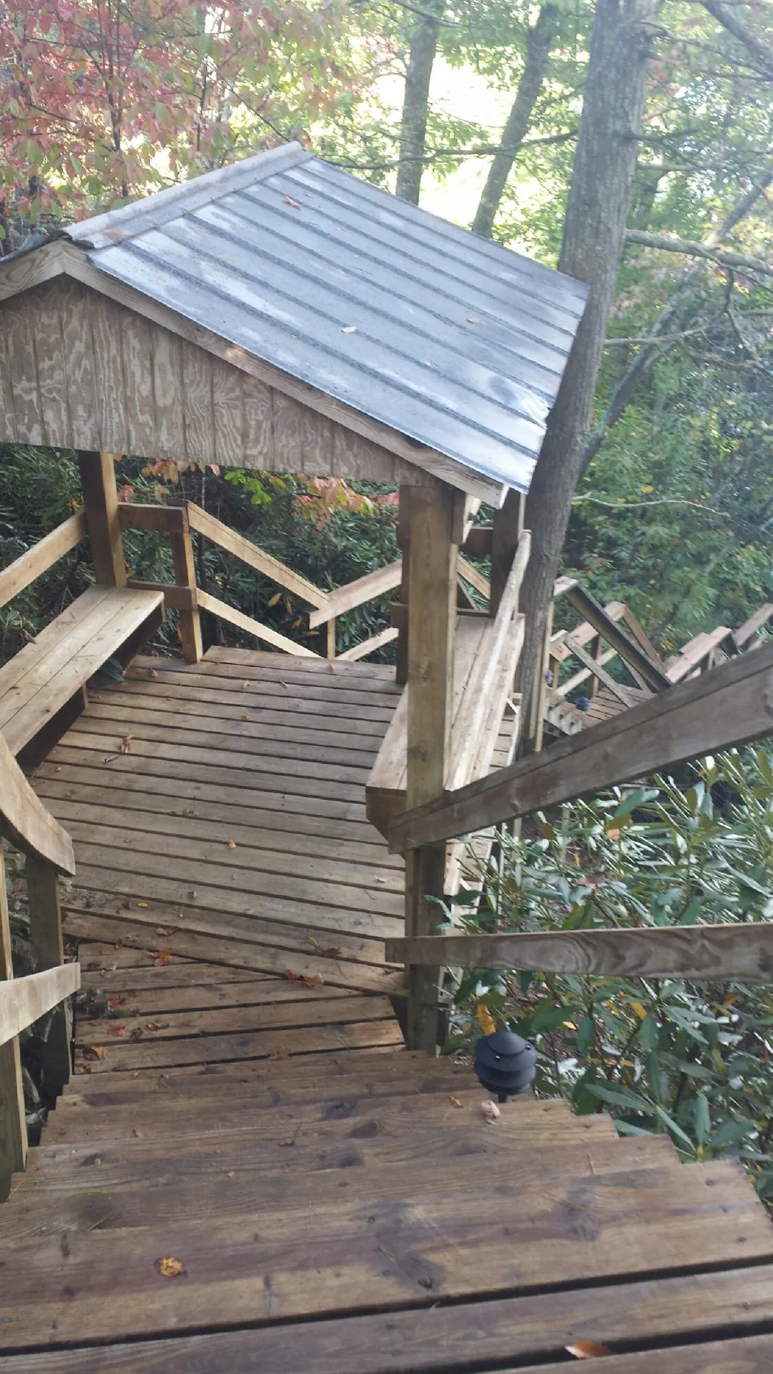Metal roofed shelter over wooden steps on a wooded walkway — Skylight Repair & Installation work by our crew in Pennville