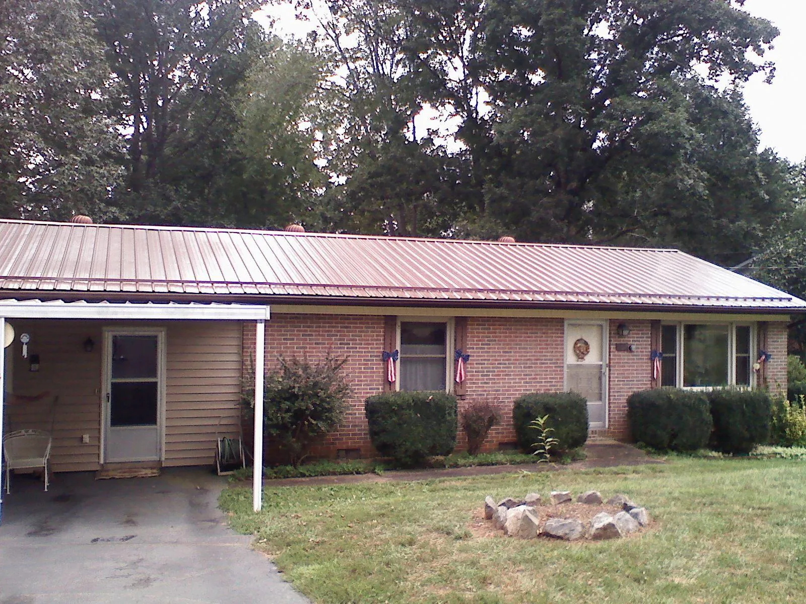Bronze metal roof and carport on a brick ranch home — Roof Repair work by our crew in Pennville